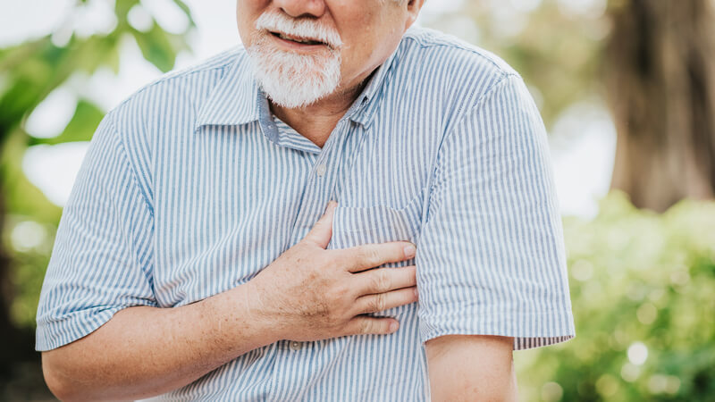 Older man with frown and hand over his heart 